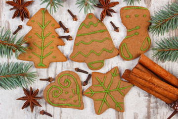 Decorated gingerbread, spruce branches, spices on old wooden background, christmas decoration