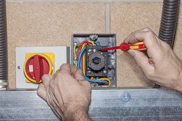 electrical engineer wiring a three phase isolator switch
