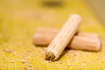 Macro view of screwdriver and wooden dowels on the table