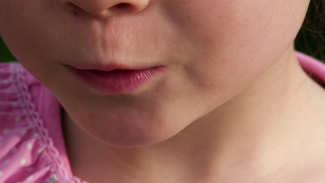 Makro: Ein kleines M&auml;dchen isst eine frische Erdbeere aus dem Garten - Teil 1