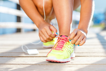 Running shoes - woman tying shoe laces. Closeup of female sport