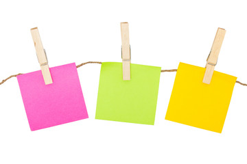 Colorful sticky notes with clothespins isolated on white backgro