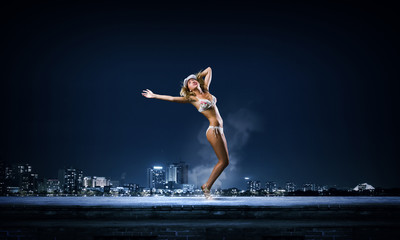Fototapeta na wymiar Dancing blonde in bikini