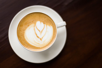 Hot art Latte Coffee in a cup on wooden table and Coffee shop bl