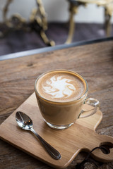 Hot art Latte Coffee in a cup on wooden table and Coffee shop bl