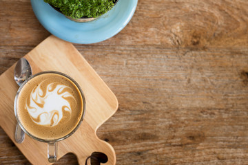 Hot art Latte Coffee in a cup on wooden table and Coffee shop bl
