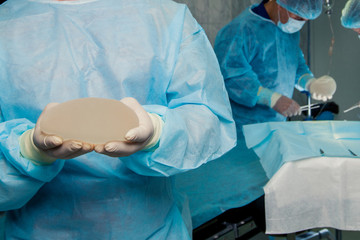 Team surgeon at work in operating room. breast augmentation.