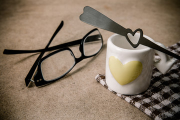 Cup of coffee and glasses on wooden table. colour of vintage sty
