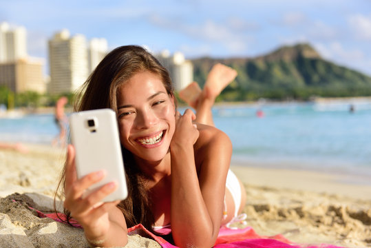 Smartphone woman using smart phone app on beach
