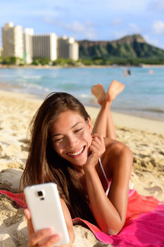 Smart phone woman using smartphone app on beach