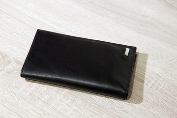 Brown leather wallet on wooden desk background