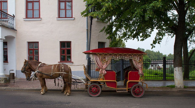 Карета и запряжённые лошади стоят на улице в городе Суздаль. Россия.