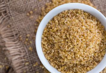 Raw Bulgur (on wooden background)