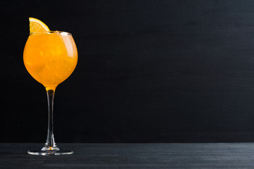 Orange cocktail with ice and oranges on the wooden background