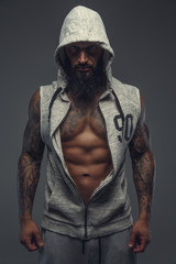 Brutal muscular tattooed gay in grey sports costume.