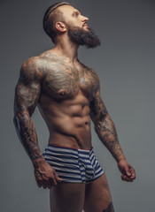 Brutal tattooed man in stripes panties.