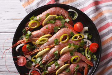 shrimps with herbs and vegetables close-up in a pan. horizontal top view
