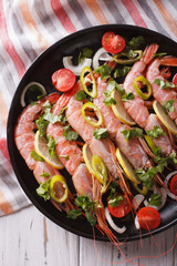 shrimps with herbs and vegetables close-up in a pan. vertical top view
