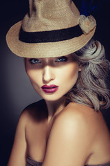 Woman with beautiful makeup and stylish hat looking at camera