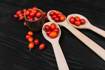 Hawthorn on wooden rustic table background. Rose hips haw fruit of the dog rose