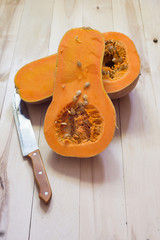 Butternut squash cut in half on a wooden surface
