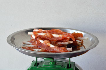 dog snack chicken jerky on stainless weighting scale tray