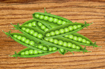 Green fresh peas on wooden texture close-up