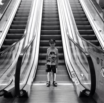 Fototapeta Chłopiec przy ruchomych schodach
