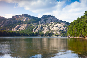 Fototapeta na wymiar Wild landscape with still lake and mountains