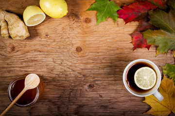tea with honey and ginger on a wooden table with autumn leaves