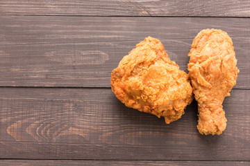 Fried chicken breast and chicken drumstick on a wooden background