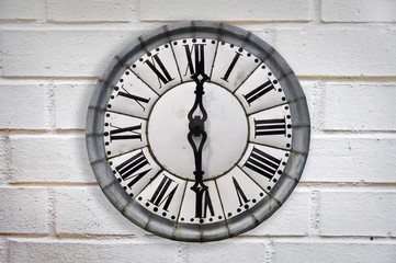 Vintage retro style clock on a white brick wall