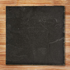 Squared black slate on wood background