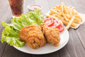fried chicken and french fries on a wooden background