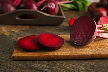 Young beets with leaves on wooden table close up
