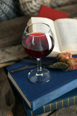Beautiful composition with glass of wine with old books on table close up