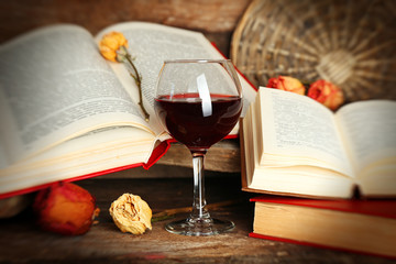 Beautiful composition with glass of wine with old books on table close up