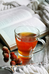 Cup of tea with book on metal tray, closeup