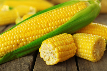Fresh corn on cobs on rustic wooden table, closeup