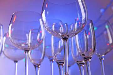 Empty wine glasses on color background