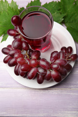 Glass of grape juice on wooden table, closeup
