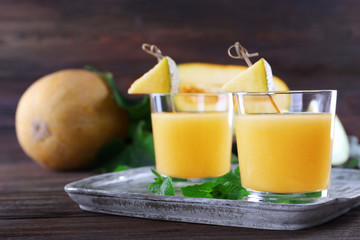 Glasses of melon cocktail on wooden background