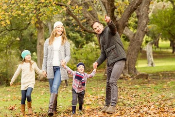 Young family running in leaves
