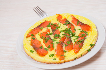 omelet with smoked salmon in a frying pan