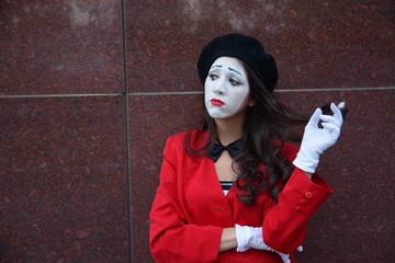 the girl is MIME standing at the wall