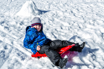 Fototapeta na wymiar Winter break. Child sledding.