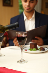 Young attractive man at the restaurant. Focus on wine glass