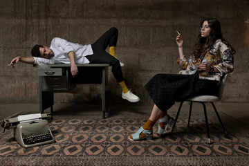 Young couple smoking and drinks in vintage room