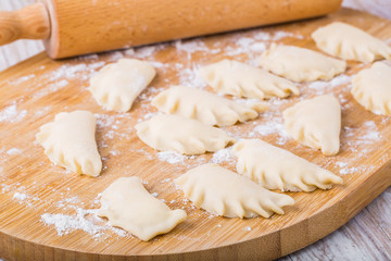 Dumplings with cottage cheese on a floured board.