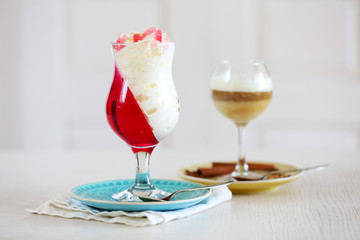 Tasty Jelly desserts with cream on light background